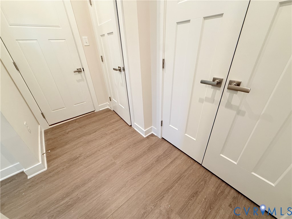 Wood-finish flooring, white four-panel interior doors, and satin nickel lever hardware