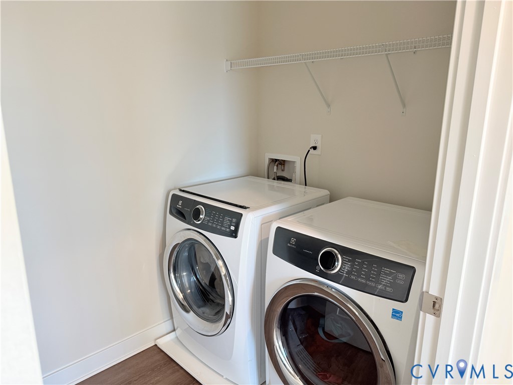 Laundry closet featuring wood-finish flooring and integrated overhead wire shelving