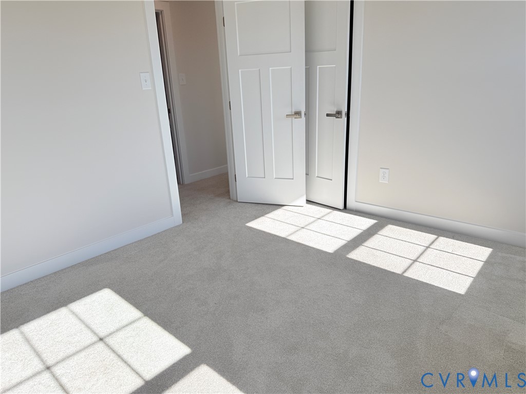 Neutral-toned carpeting, shaker-style interior doors, and modern satin nickel hardware