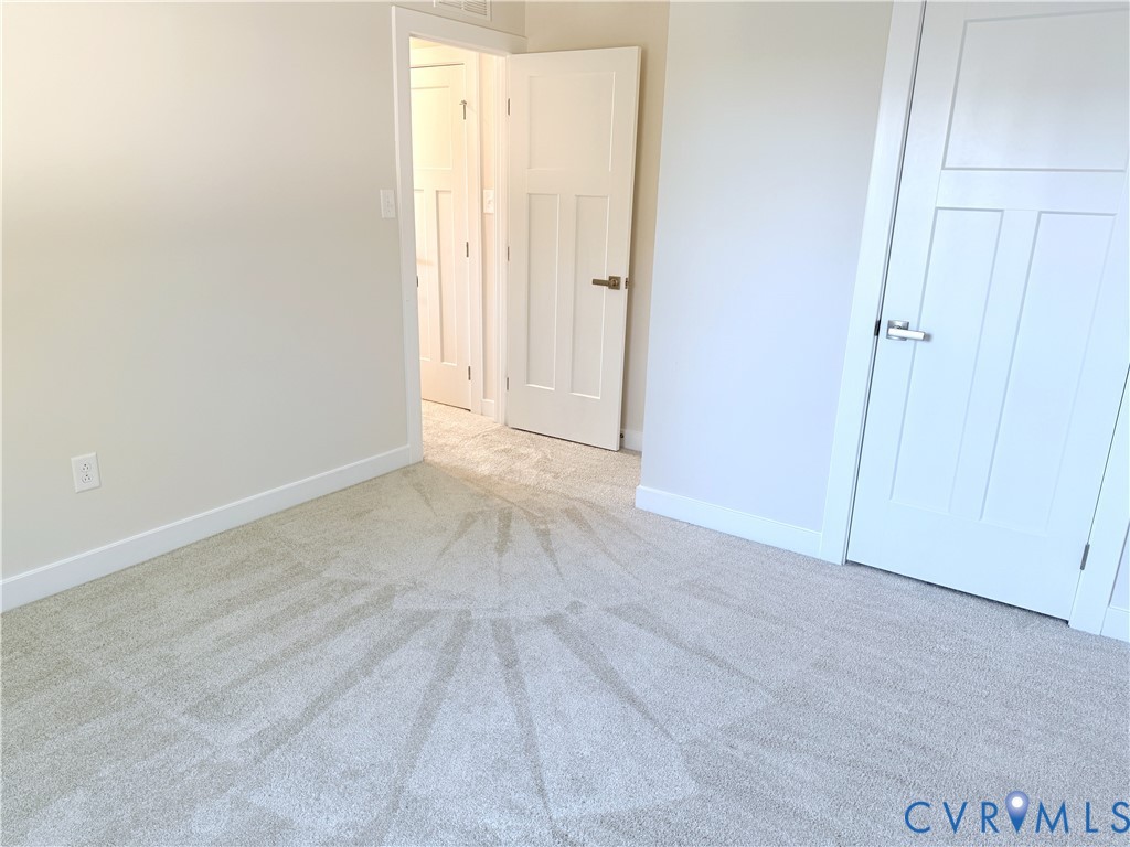 Neutral wall-to-wall carpeting, three-panel interior doors, and modern satin-nickel hardware
