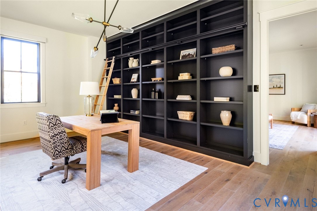 Private primary ensuite office with custom libary built-ins featuring rolling ladder and bright natural light.