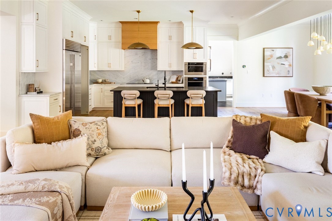 Random-width hardwoods, gas FP, sliders to covered porch, open to kitchen and dining areas.