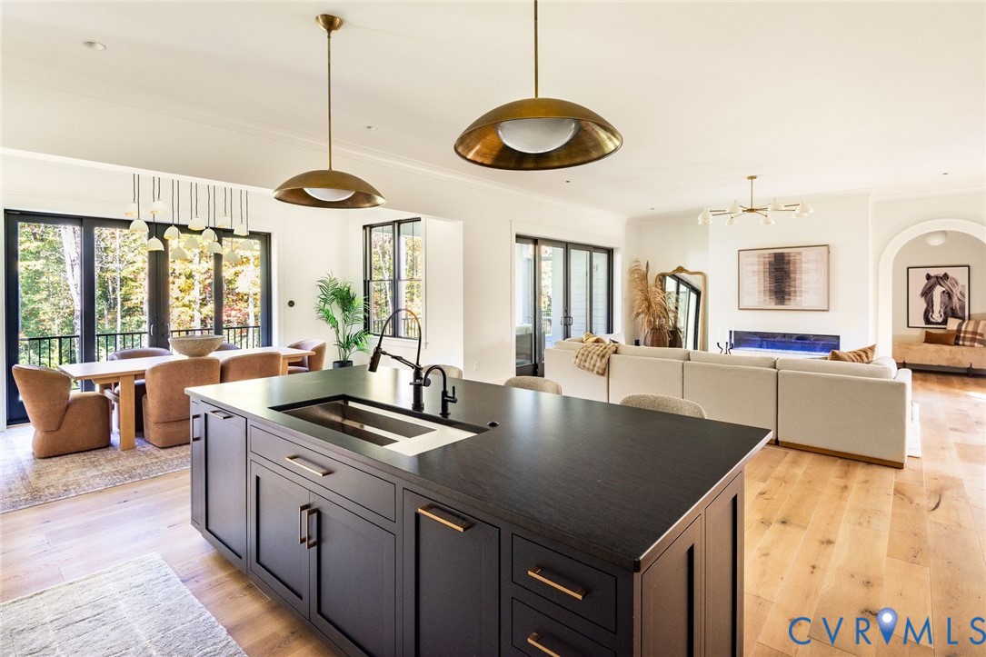 Chefs kitchen with premium appliances, Wolf induction cooktop, hidden pantry, quartzite island, leathered marble counters, access to multifunctional mudroom, open to dining and living areas.