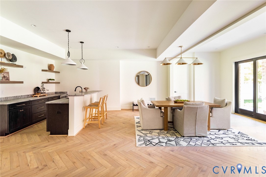 Kitchenette and dining areas with access to a hobby or flex room, sliders to outside and nearby full bath.