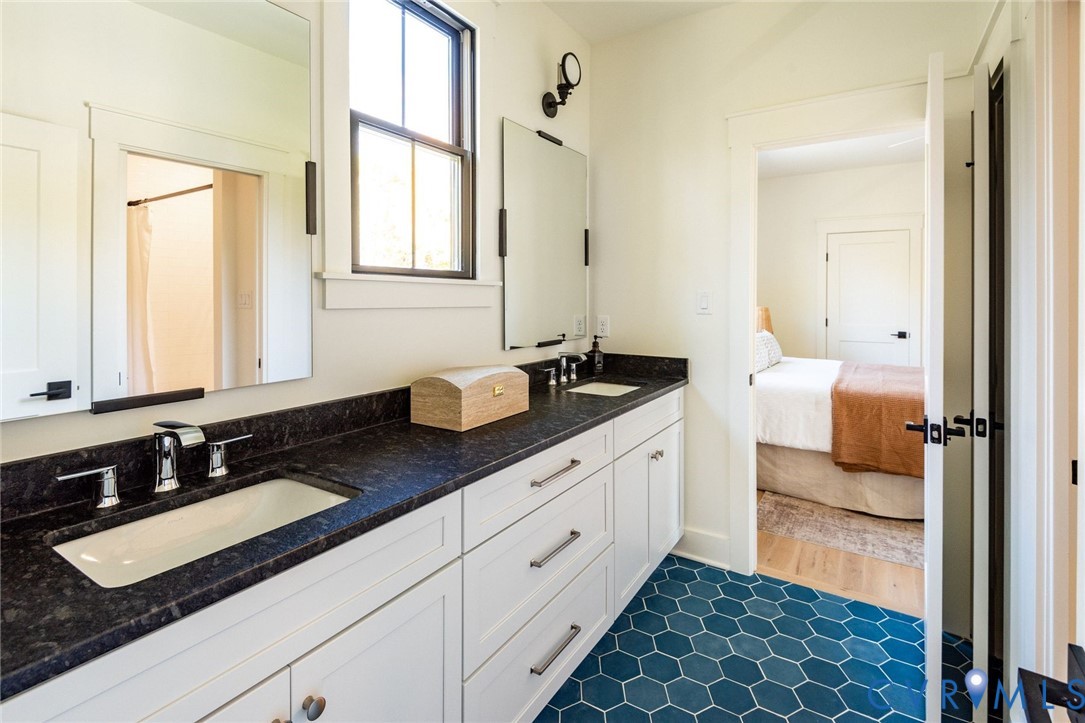 Jack-and-Jill bathroom with separate tub/shower area, double sinks, custom vanities and designer tile.