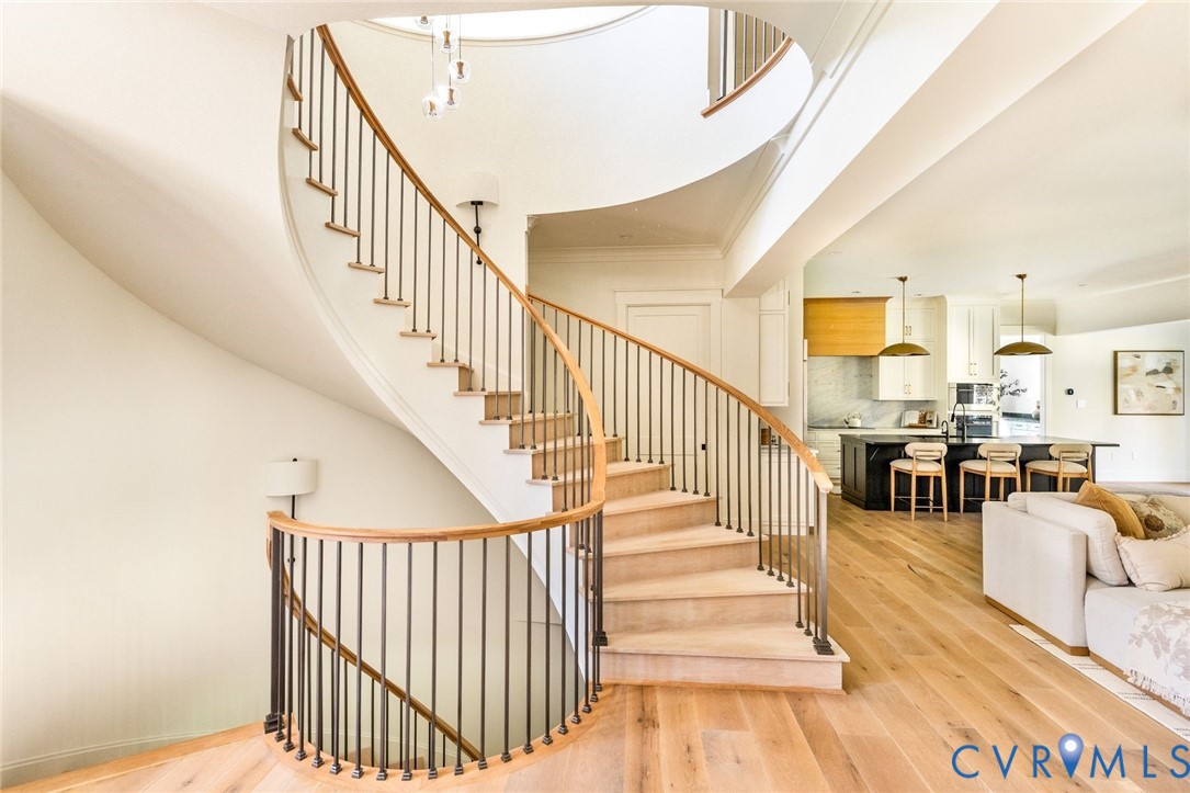 Sweeping staircase, random-width floors, soaring ceilings, open spaces.