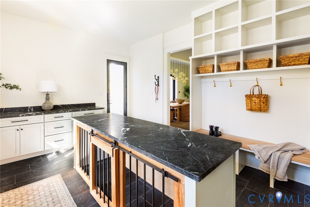 Custom dog-crate island, cubbies, rear and garage door access, custom cabinetry and laundry.