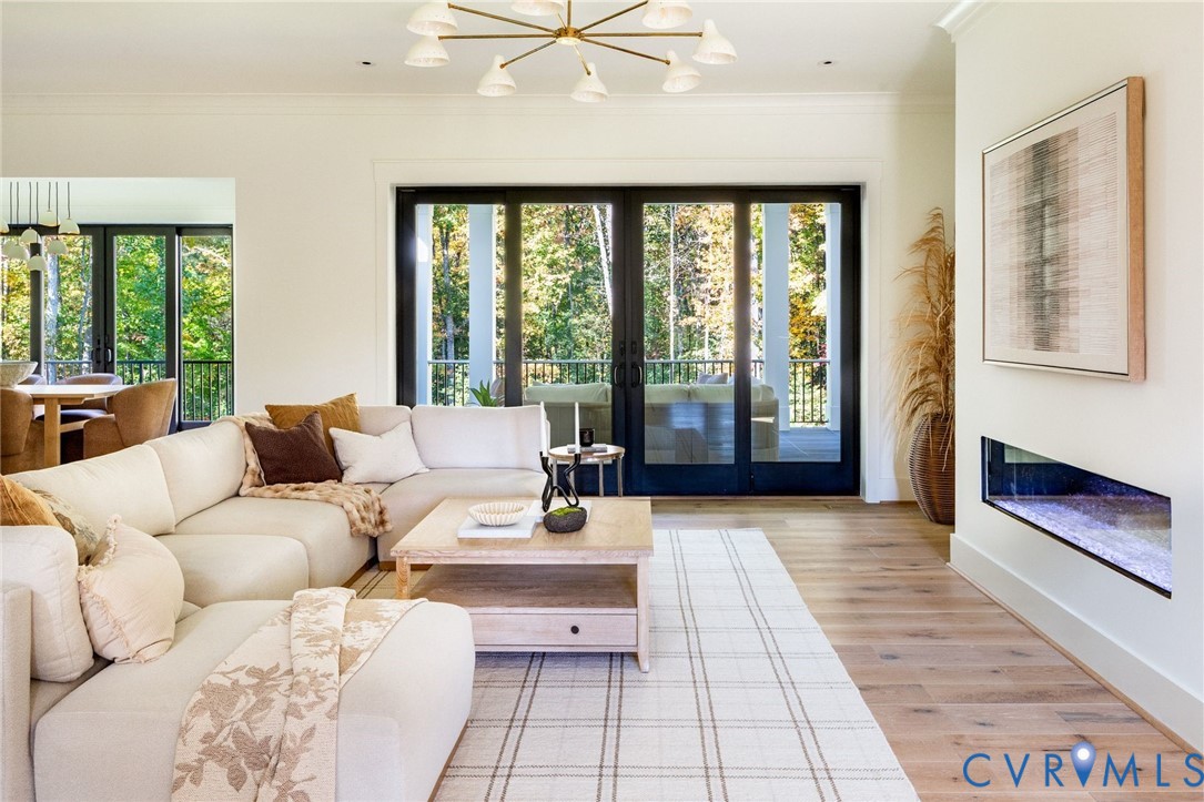 Random-width hardwoods, gas FP, sliders to covered porch, open to kitchen and dining areas.