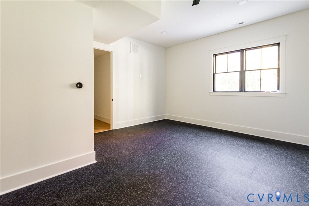 Lower level workout room with exercise floor and nearby full bathroom.
