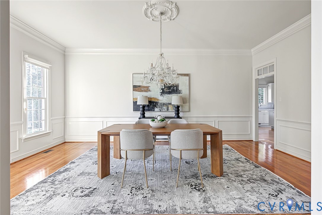 Sophisticated chandelier, wainscoting and hardwoods create the perfect ambiance.