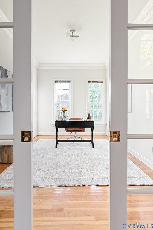 Step through French pocket doors into the home office with chic new lighting and hadrwoods.
