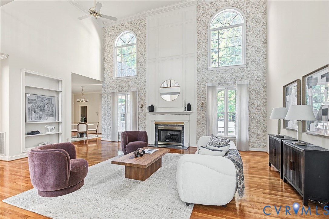 Show stopping living room with floor to ceiling windows with Kid Manwell curtains, gas fireplace and built ins.