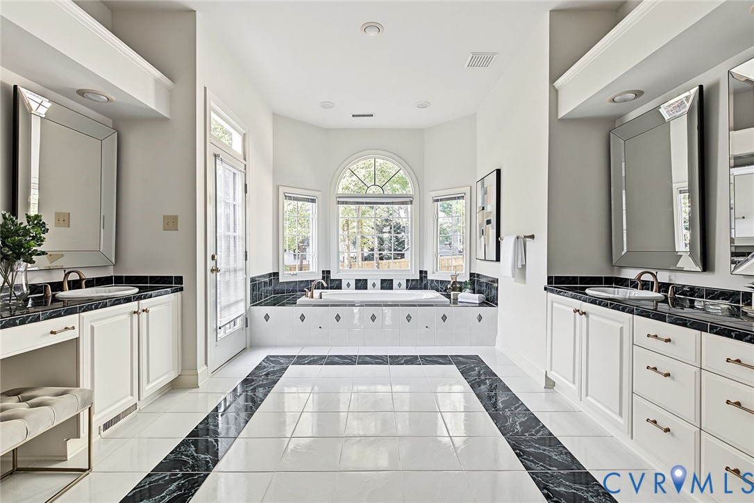 The primary bath features dual vanities and a jetted tub.