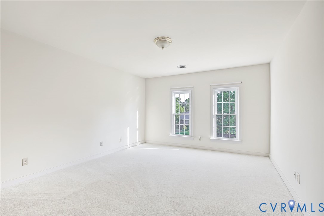 Bedroom 3 with serene palette and large closet with custom wood shelving.