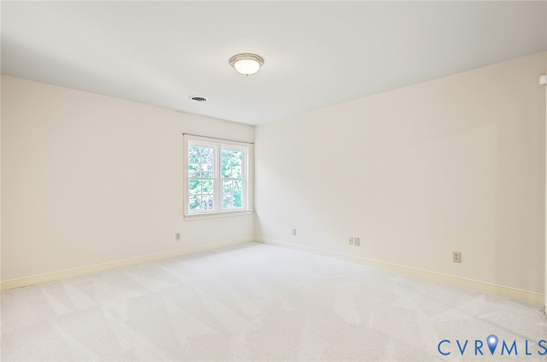 Bedroom 4 with clean palette and large closet with custom wood shelving.