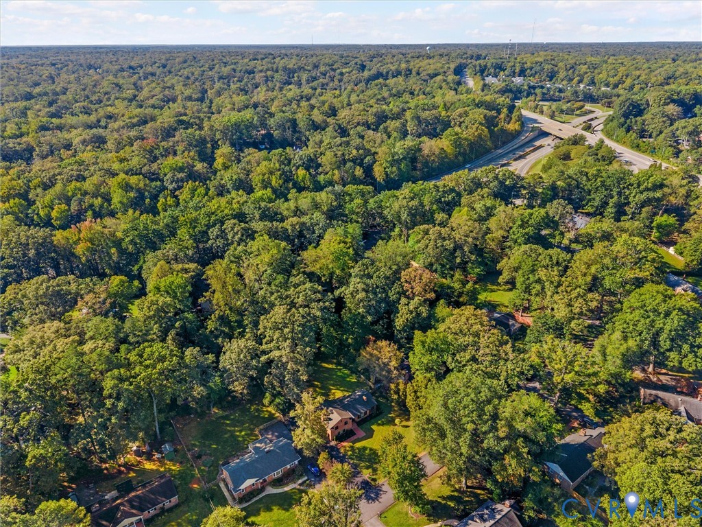 Aerial perspective featuring a residential lot surrounded by a dense canopy of mature trees and established woodland Aerial perspective featuring a residential lot surrounded by a dense canopy of mature trees and established woodland