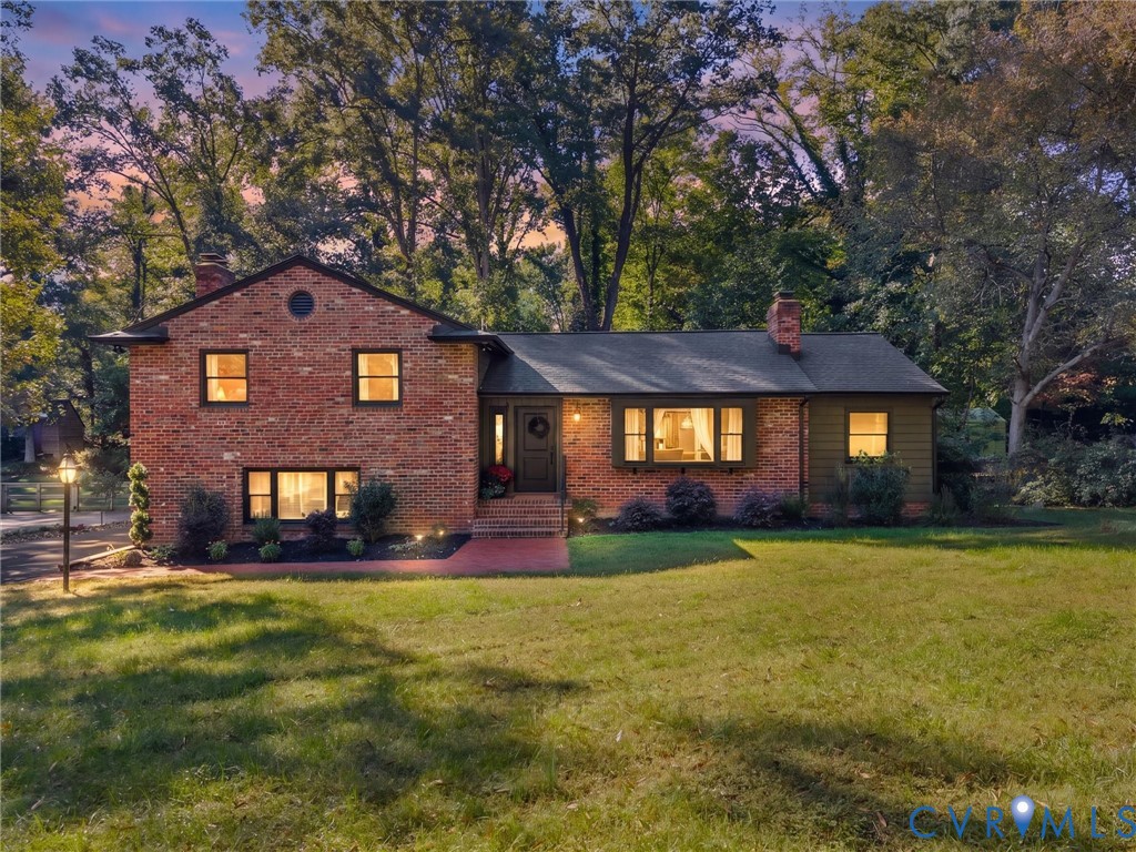 Brick and siding exterior featuring a multi-level roofline, prominent bay window, brick entryway, and mature tree-lined lot Brick and siding exterior featuring a multi-level roofline, prominent bay window, brick entryway, and mature tree-lined lot
