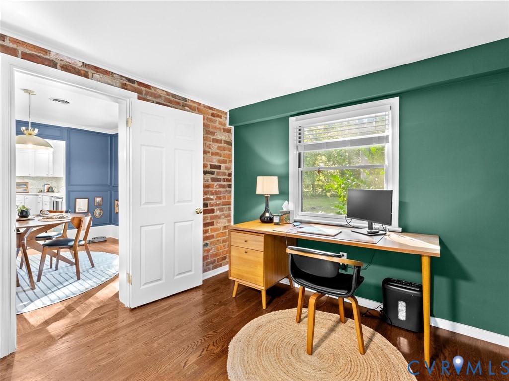 Exposed brick wall accents, wood-finish flooring, and a multi-pane window