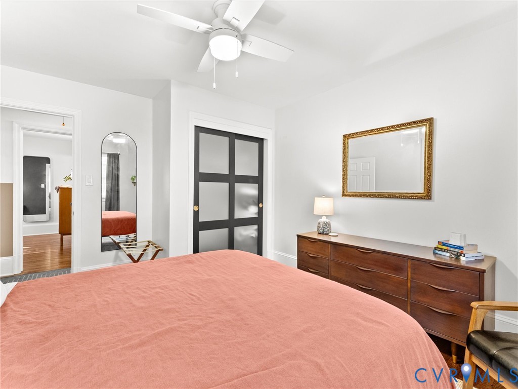 Room featuring a ceiling fan with integrated lighting and sliding closet doors with frosted glass panels
