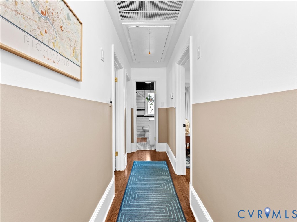 Hallway featuring two-tone wall paint, wood-finish flooring, and recessed ceiling access