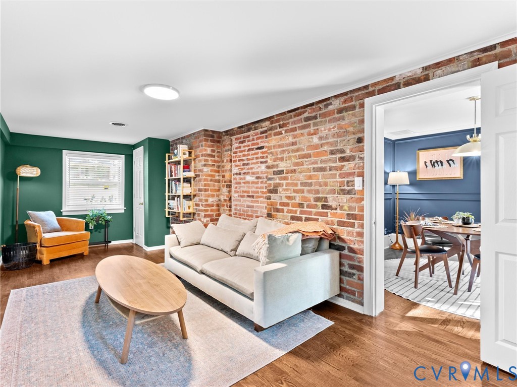 Exposed brick wall feature, wood-finish flooring, and recessed ceiling lighting