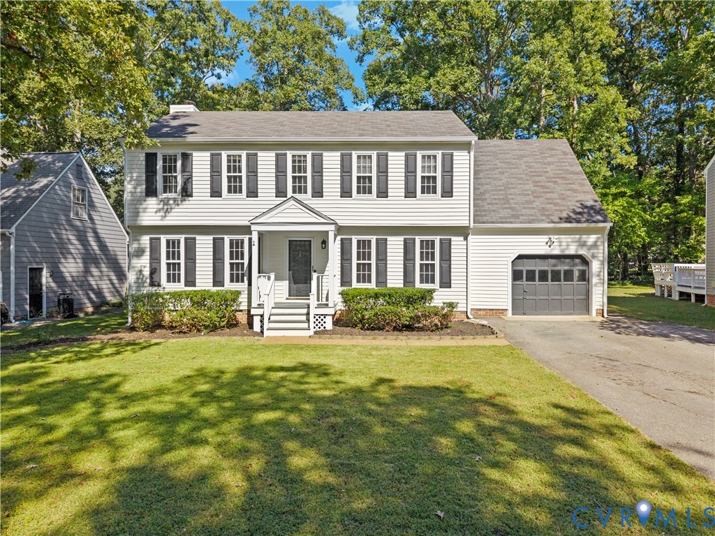 Colonial-style exterior featuring white horizontal siding, dark decorative shutters, an asphalt shingle roof, an attached single-car garage, and a covered front entryway with steps