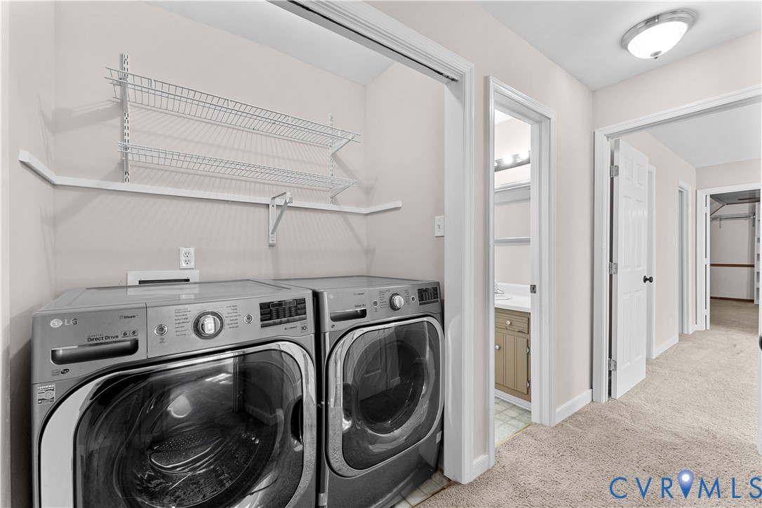 Laundry area featuring built-in wire shelving, flush-mount ceiling lighting, neutral carpeting, and panel-style interior doors