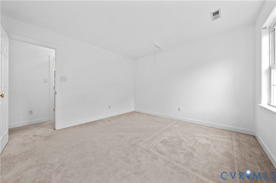 Neutral wall color, wall-to-wall carpeting, and window with natural light
