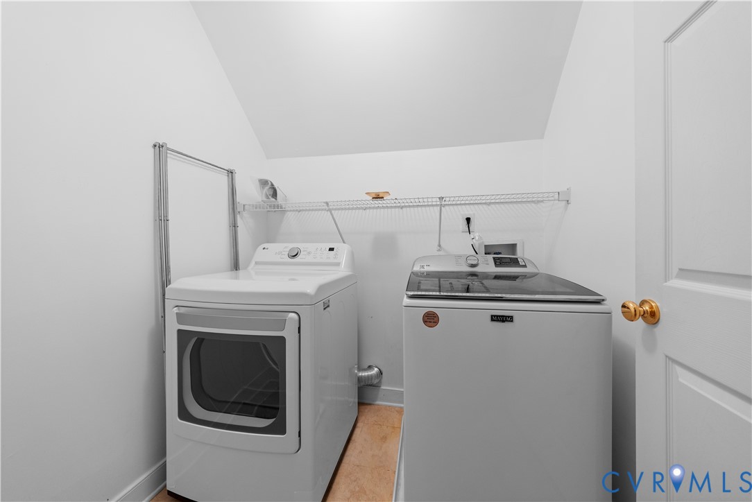 Laundry area featuring white walls, wood-finish flooring, a wall-mounted wire shelving unit, and a foldable metal hanging rack