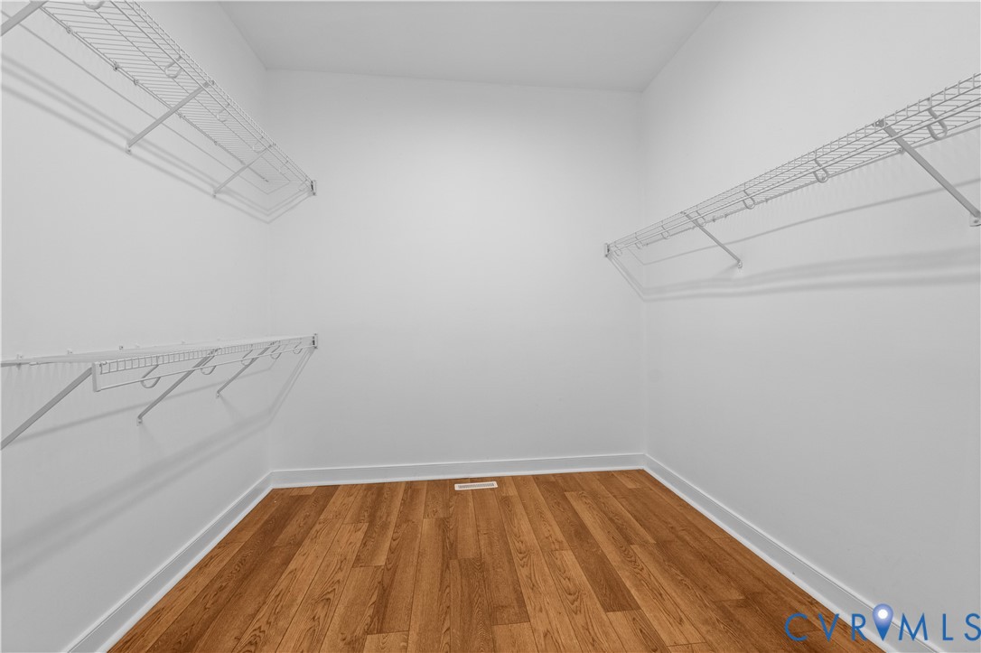 Walk-in closet featuring wood-finish flooring and multi-level white wire shelving