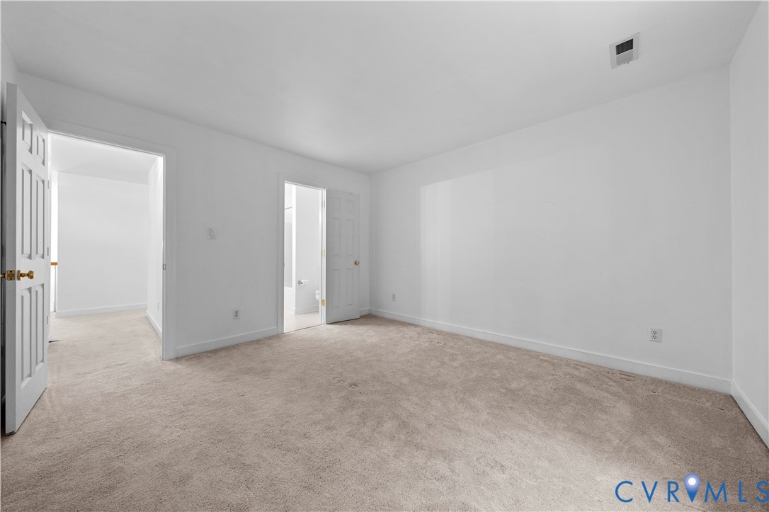 Neutral wall-to-wall carpeting, six-panel interior doors, and crisp white wall finishes