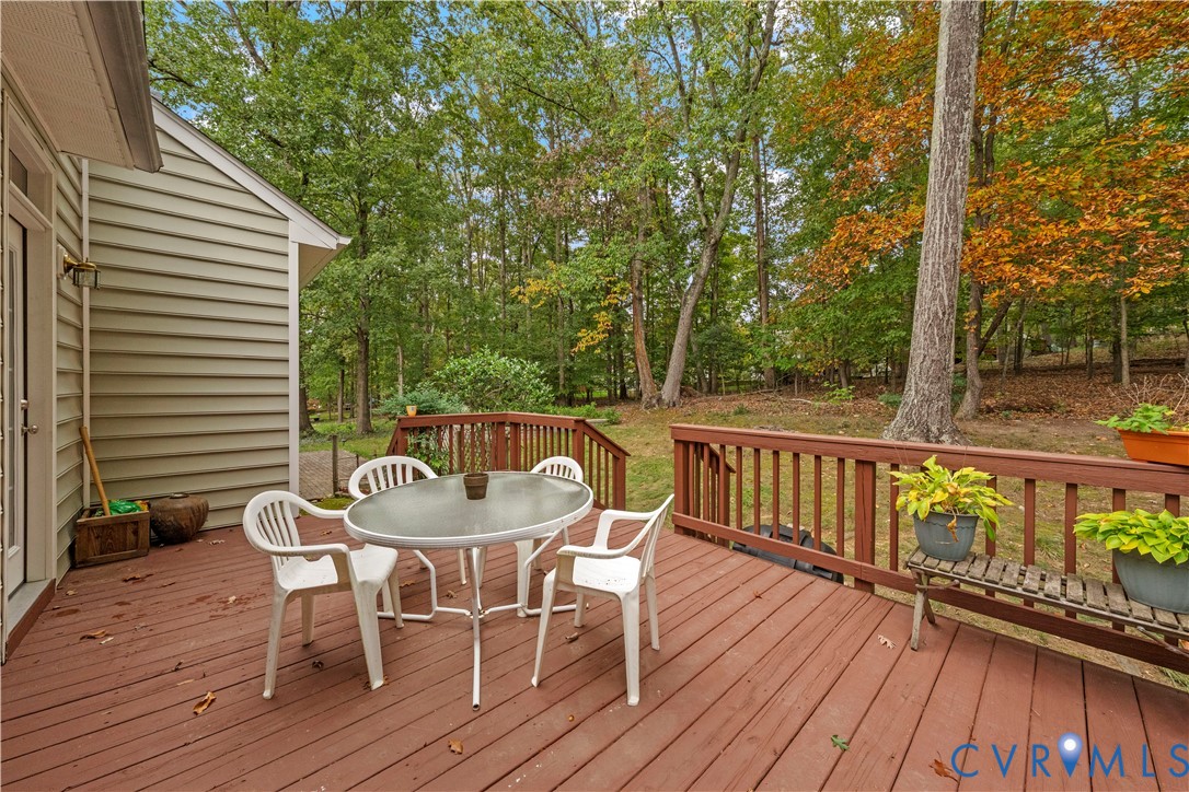 Raised wooden deck with perimeter railings and light-toned horizontal siding