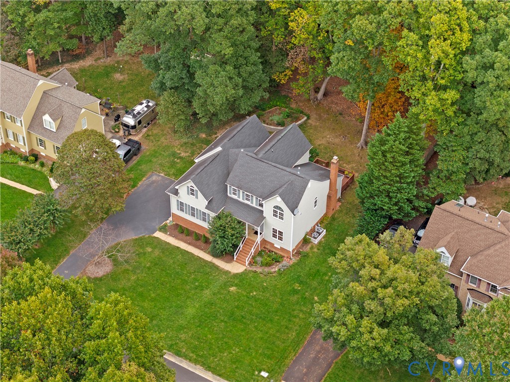 Two-story residence featuring a multi-gable asphalt shingle roof, brick and horizontal siding exterior, attached chimney, and concrete stairs with metal railings