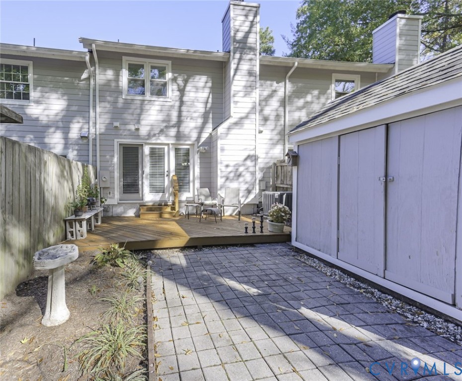 Roomy back deck with privacy fencing and a large shed for more storage.