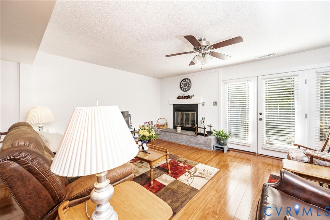 Living area featuring a fireplace with a stone-finish hearth.