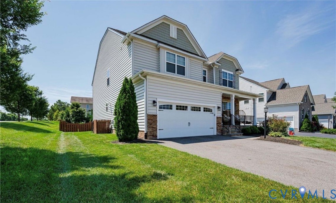 Two-story residence with a two-car garage, stone accents, and a covered front porch