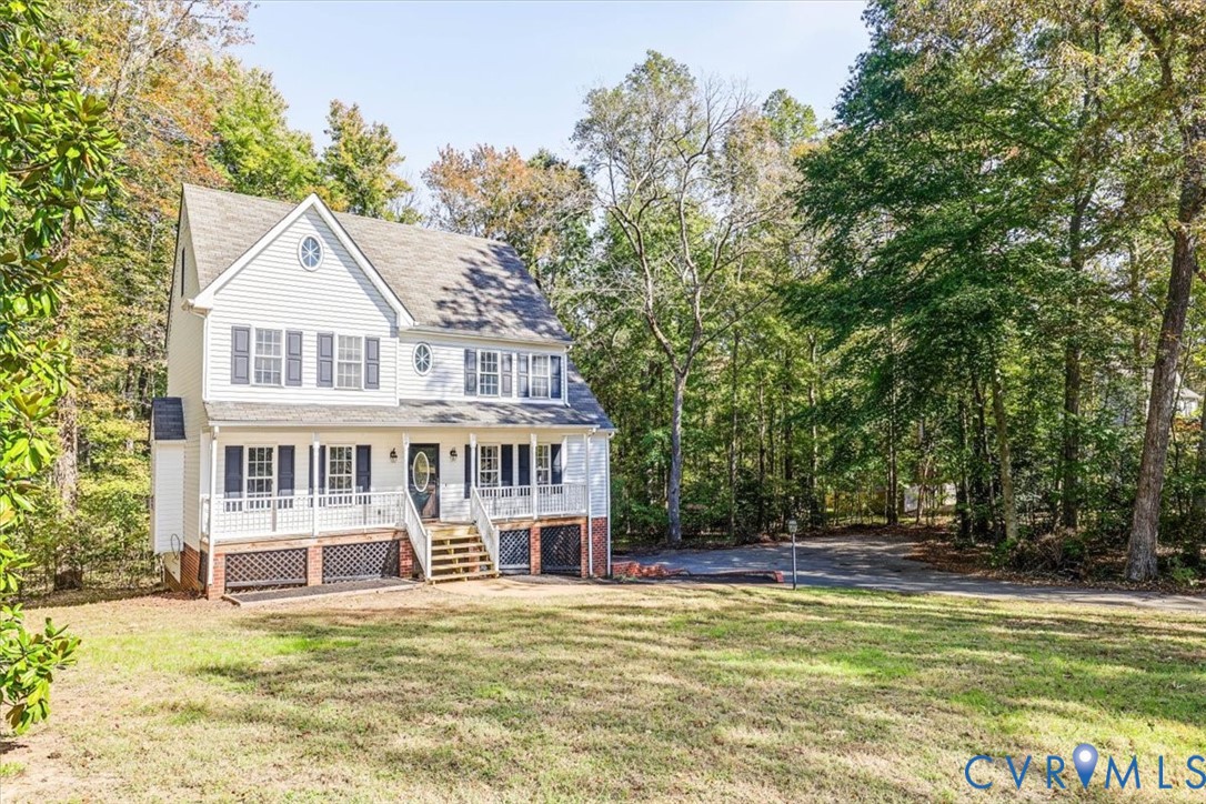 Two-story residence featuring horizontal siding, a covered front porch with a wood-staircase entry, decorative latticework under-porch detailing, and shuttered windows