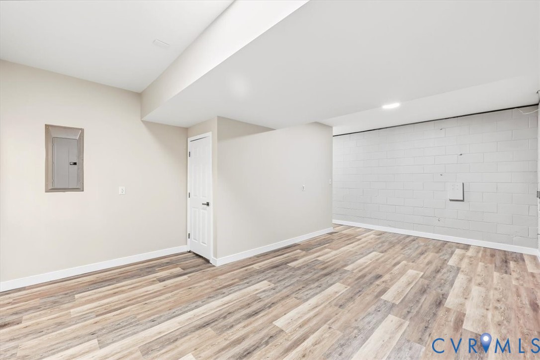 Interior space featuring wood-finish flooring, recessed lighting, and a painted masonry accent wall
