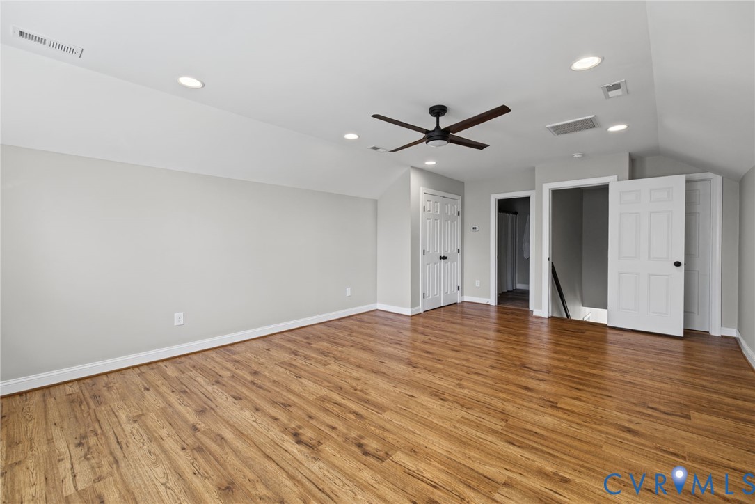 Room featuring wood-finish flooring, recessed lighting, vaulted ceilings, and a ceiling fan