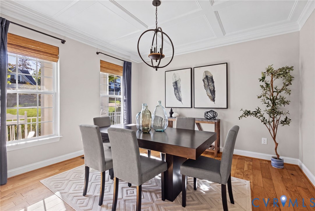 Coffered ceiling with crown molding, wood-finish flooring, and a decorative orb chandelier