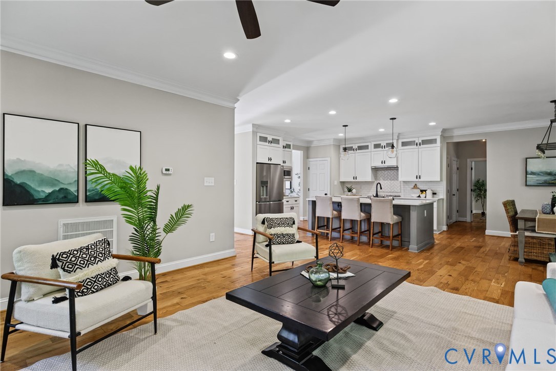 Open-concept interior featuring wood-finish flooring, recessed lighting, and crown molding