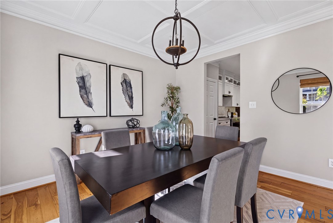 Coffered ceiling, wood-finish flooring, and orb-style metal chandelier