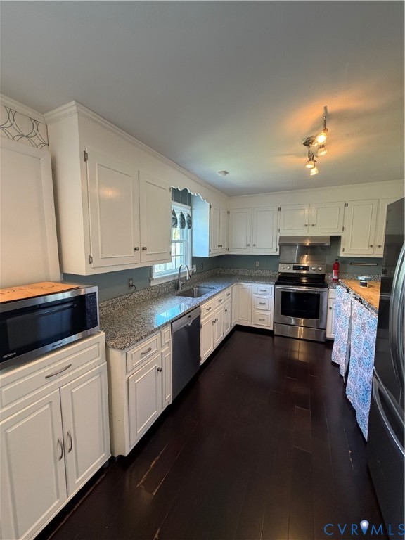 Kitchen featuring white shaker-style cabinetry, stone countertops, stainless steel appliances, and dark wood-finish flooring
