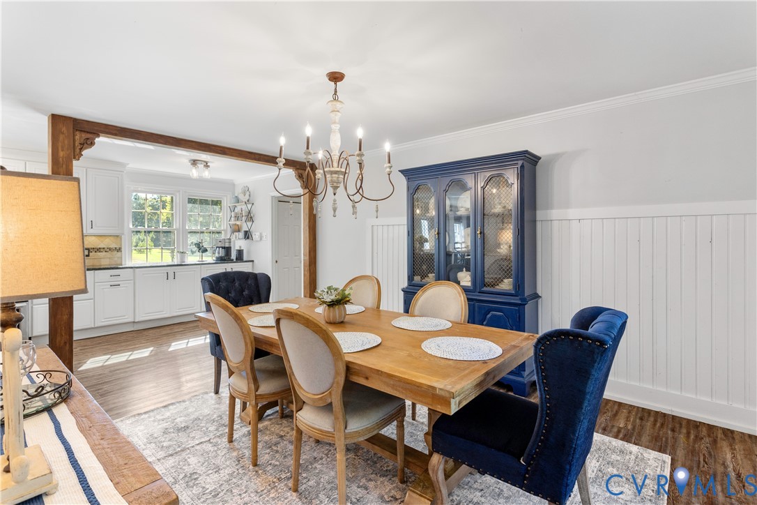 exposed wooden support beam with decorative corbels, and a multi-arm candle-style chandelier.
