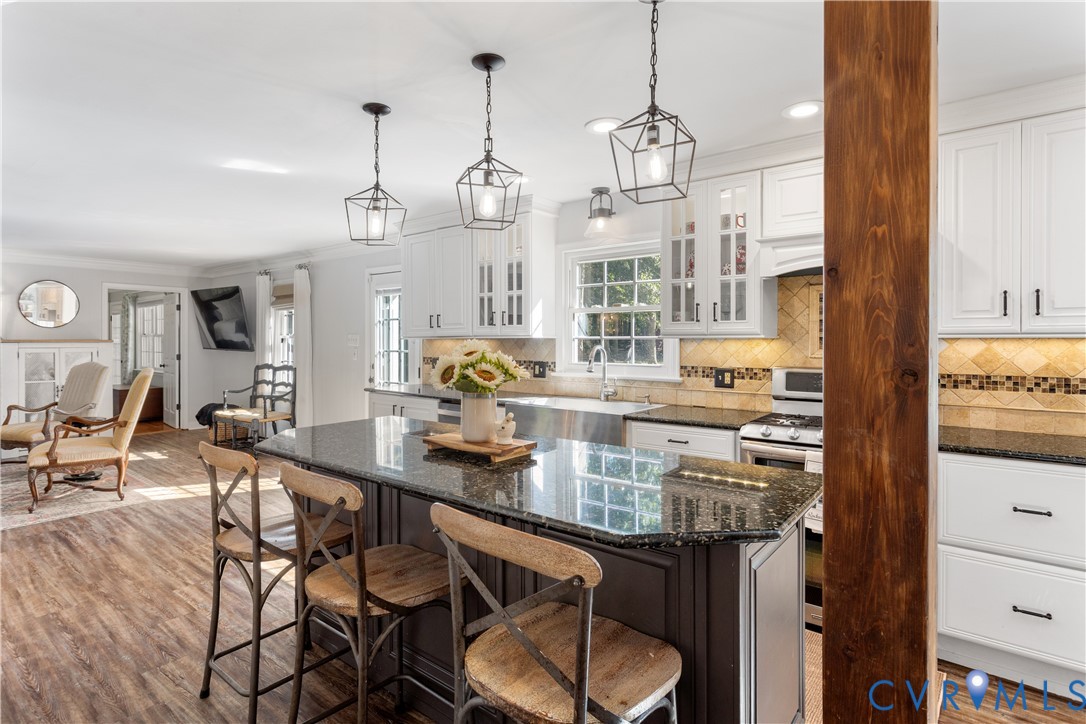 Kitchen featuring a central island. Structural beam.  Lots of bright natural light with full views of the barn and rear  concreat paito & courtyard.