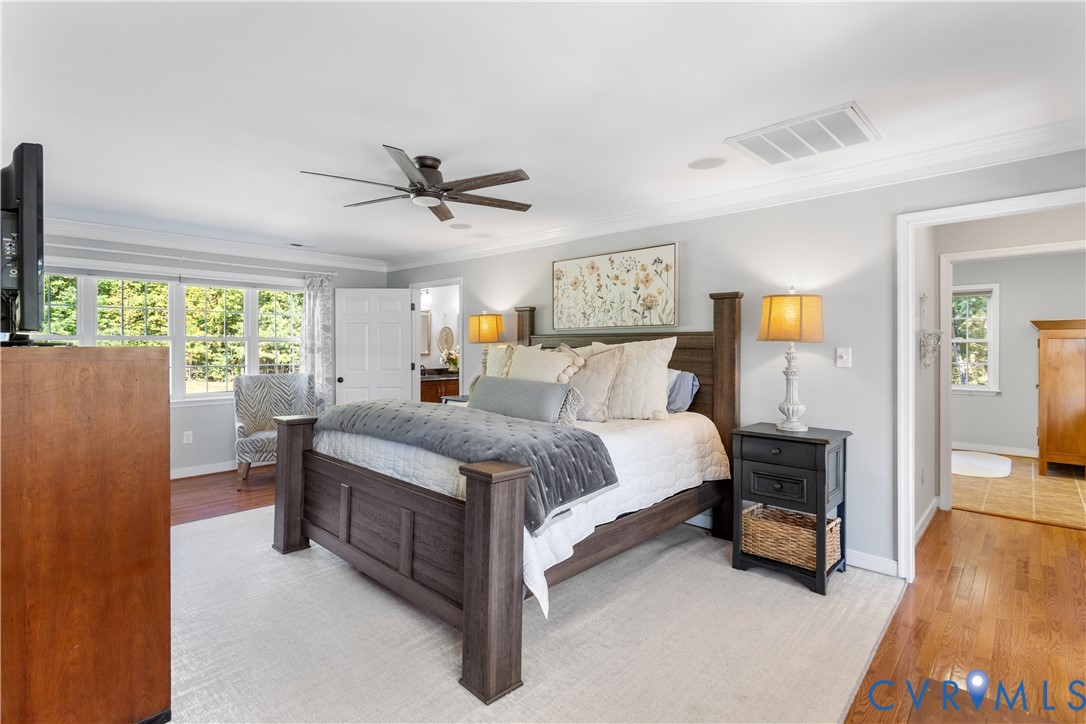1st Floor primary featuring wood-finish flooring, lots of great windows, crown molding, adjoining laundry room