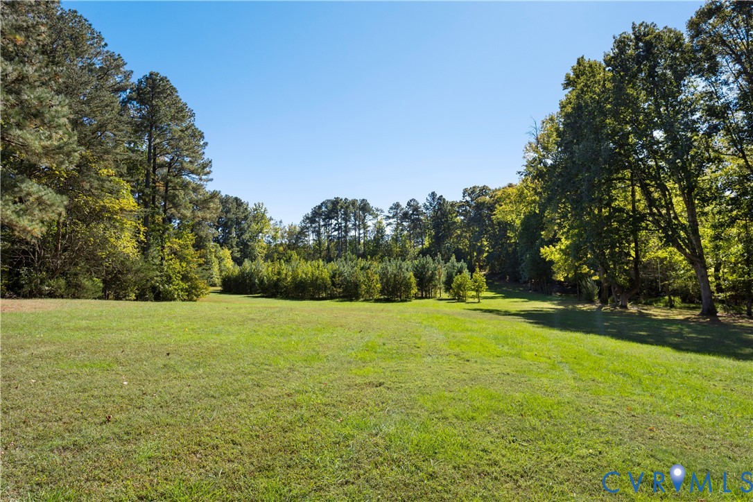 Expansive parcel featuring open green space, cleared acreage, and mature tree borders