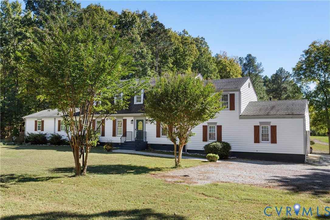 Two-story residence featuring  a gravel driveway, and an expansive lawn