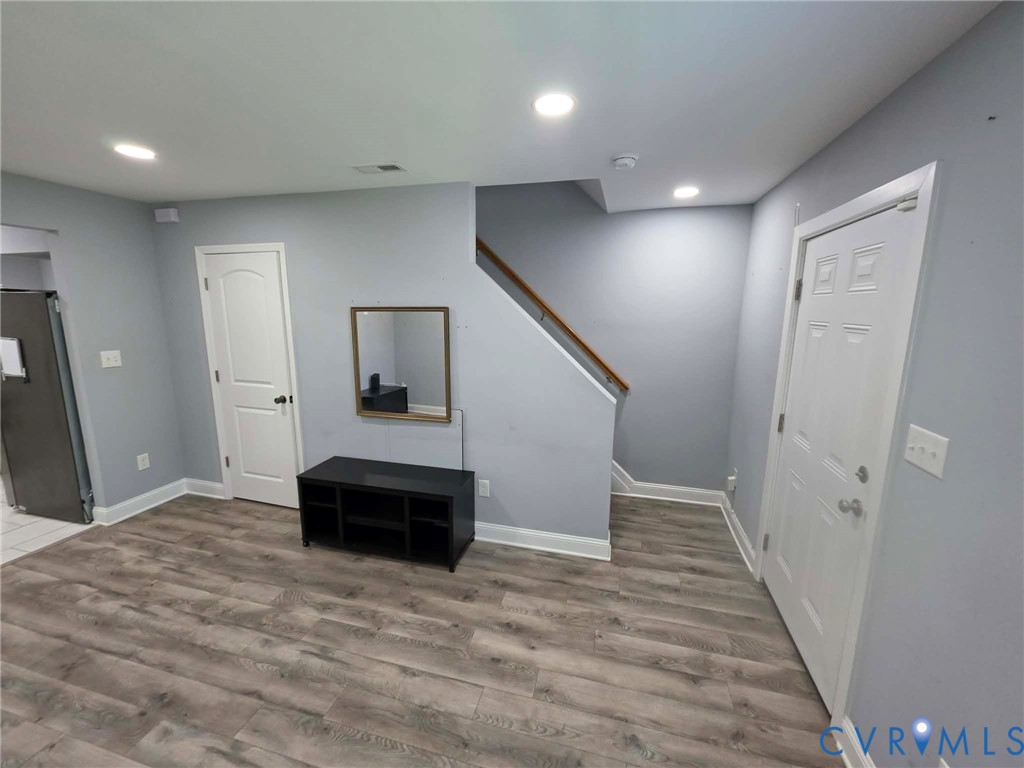 Living room featuring LVP flooring, recessed, lighting, and an open concept feel.