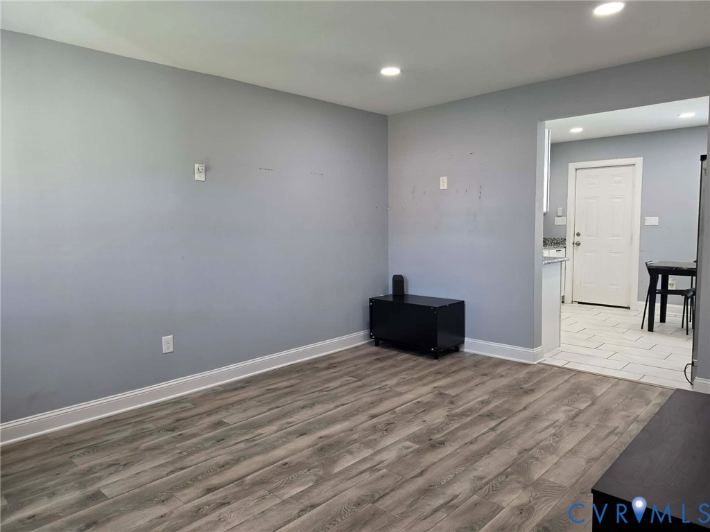 Living room featuring LVP flooring, recessed, lighting, and an open concept feel.